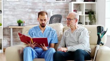 <strong>社工</strong>在养老院给一个老残疾人读一本书